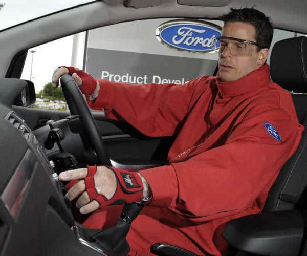 Ford Entwicklungsingenieur testet im Alterssimulationsanzug Third Age Suit die Usability der Bedienelemente eines Fahrzeug Cockpits